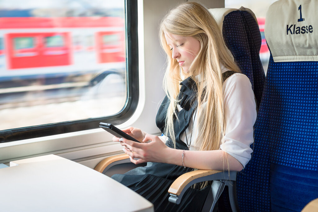 Meisje in de trein met een tablet