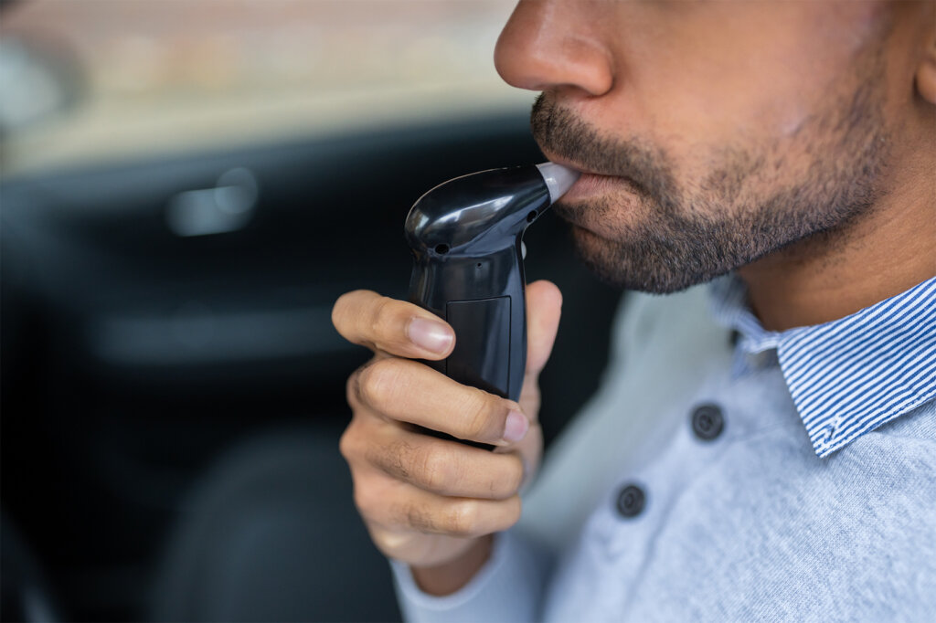 man_uses_breathalyser_in_car