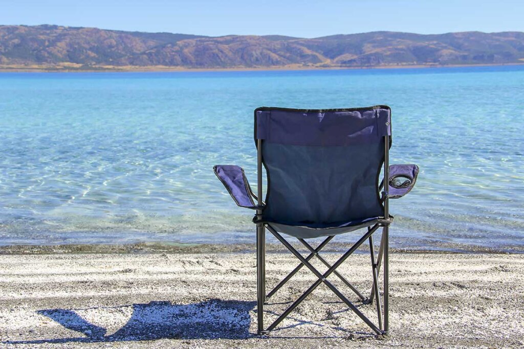 blauwe campingstoel op strand