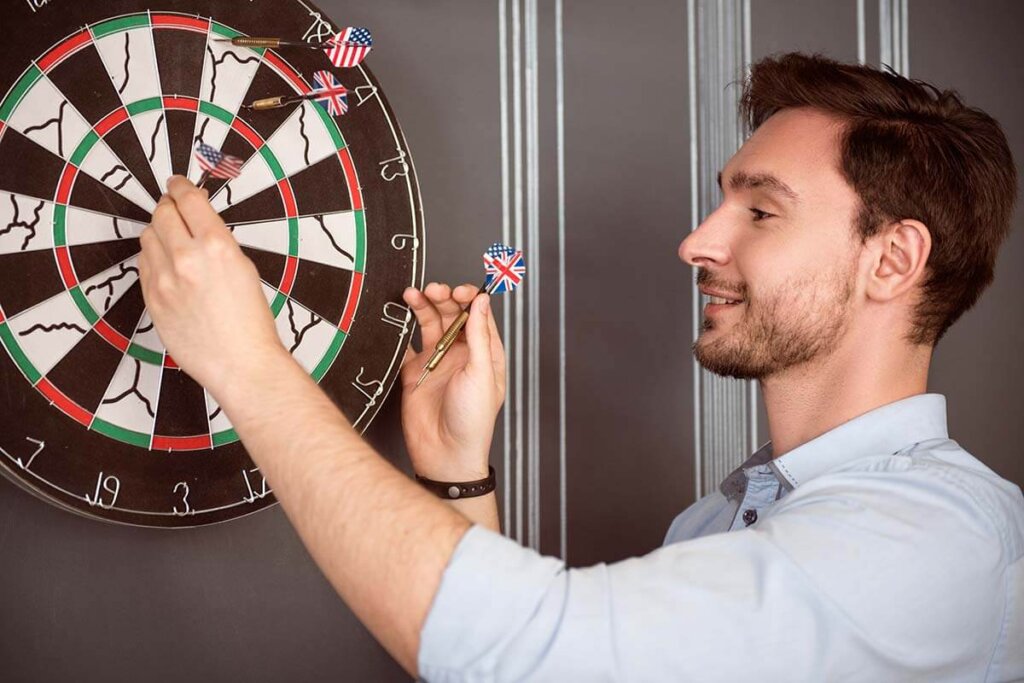 man trekt darts van bord