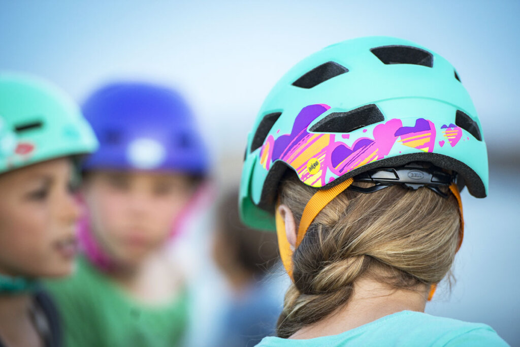 verschillende kinderen met kleurrijke fietshelmen