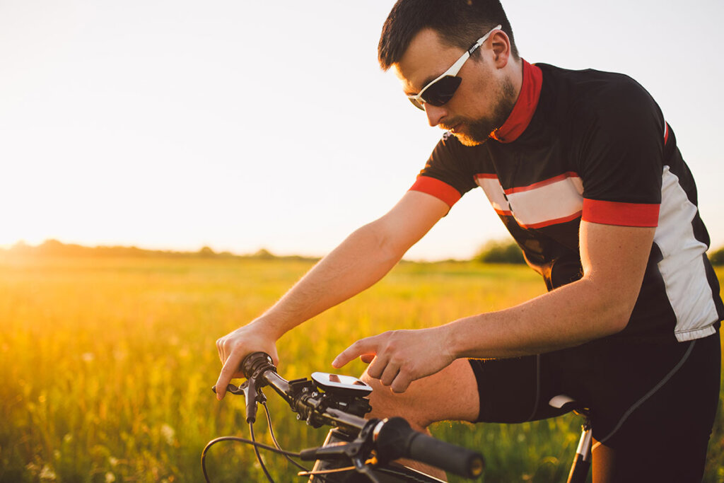 jonge fietser in het veld bedient navi