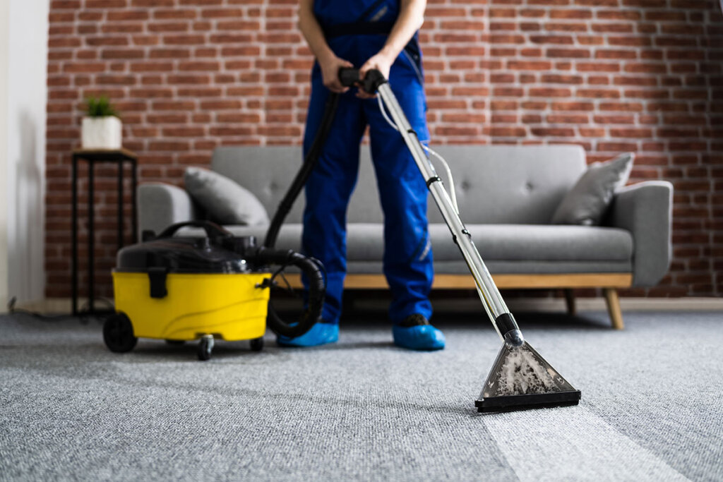 Man maakt tapijt schoon met industriële stofzuiger