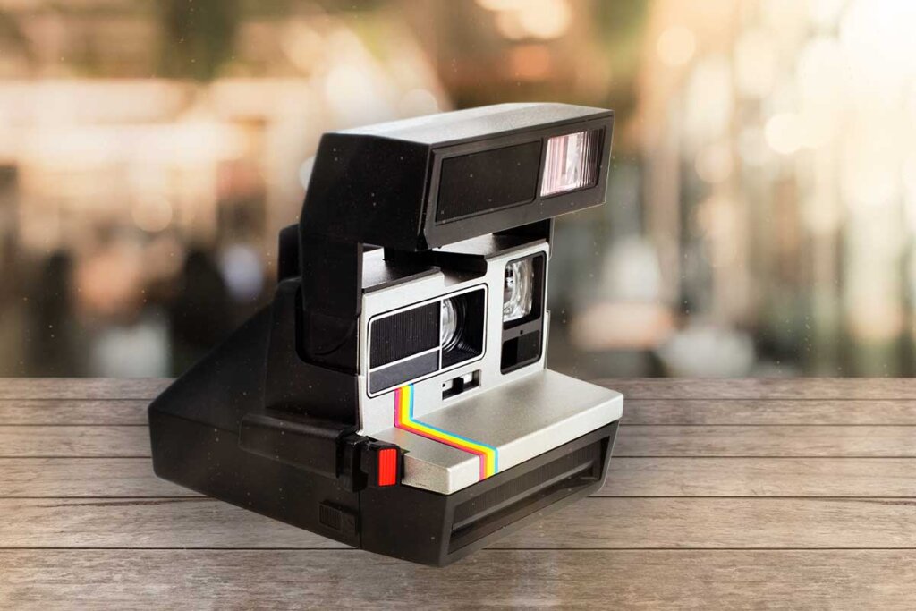 zwarte instant camera staat op houten ondergrond