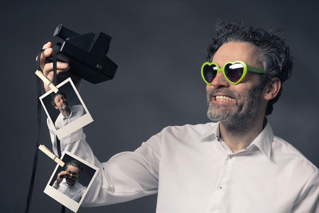 man met instant camera neemt selfies