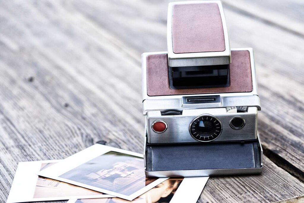 oude instant camera met foto's naast de deur