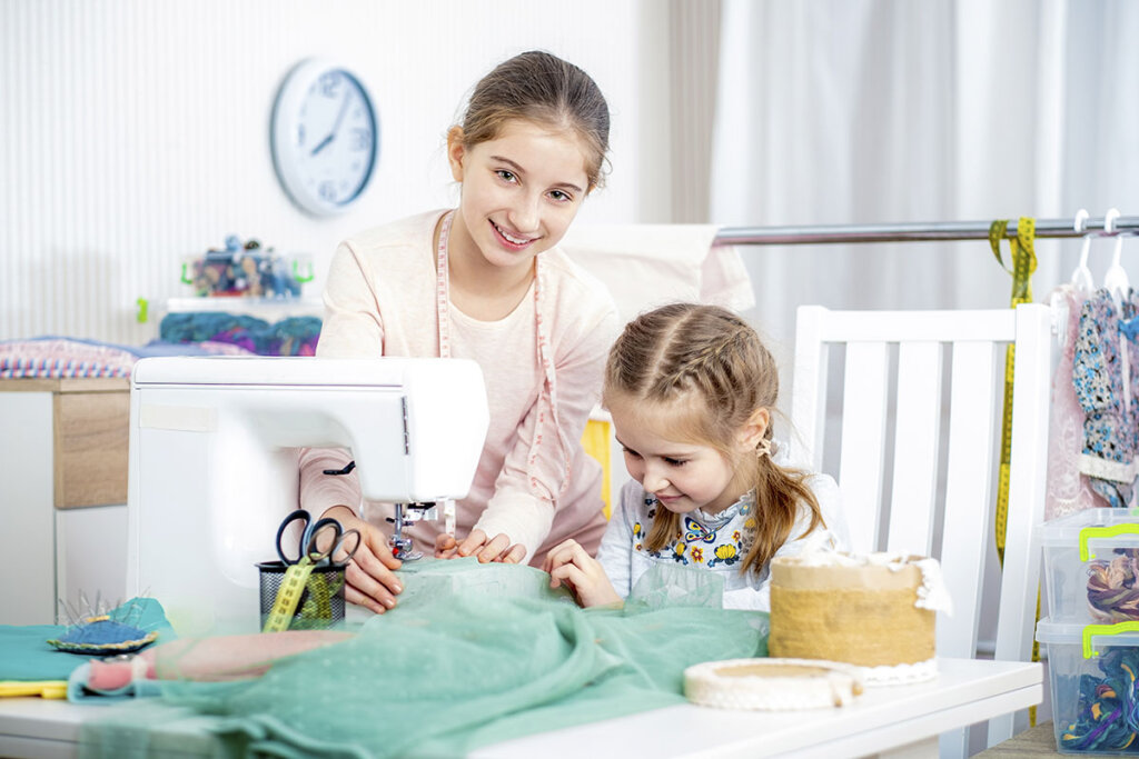 Broers en zussen naaien met een kindernaaimachine