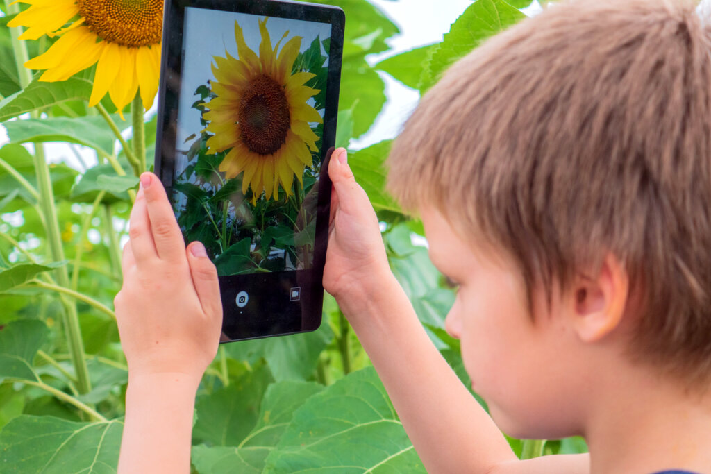 jongen neemt een foto met tablet