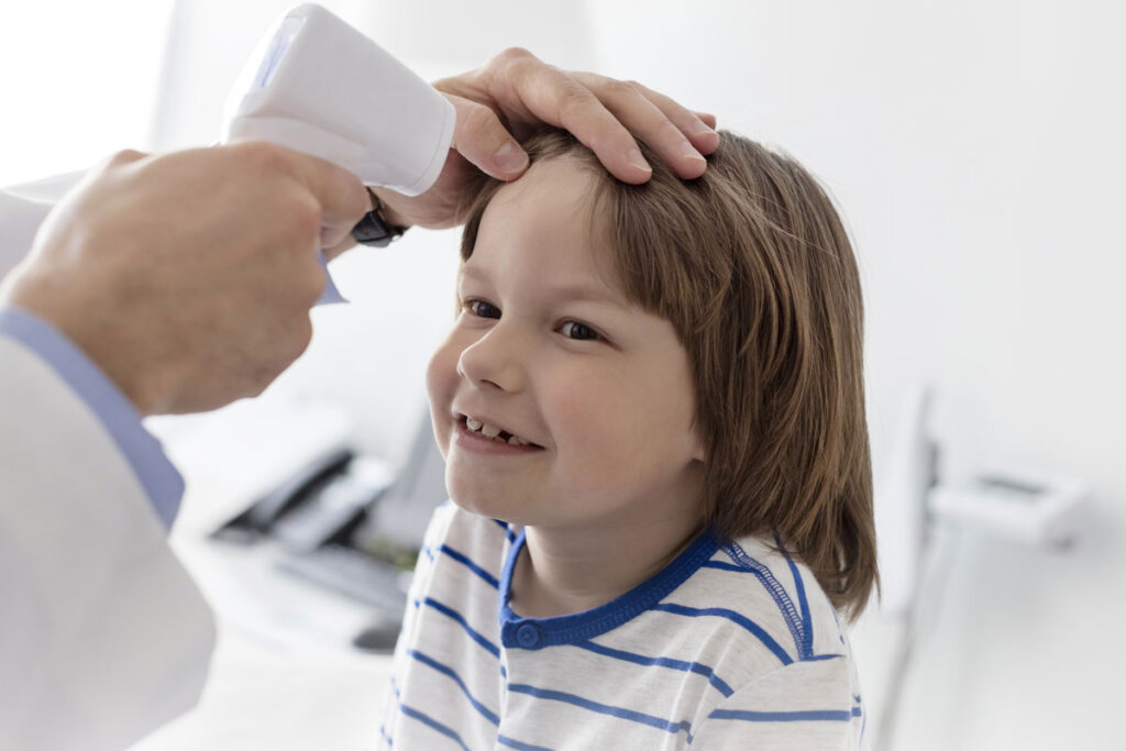 temperatuur van een jongen wordt gemeten met de voorhoofdthermometer