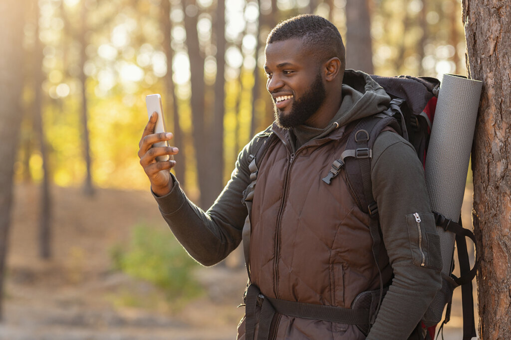 Man in bos kijkt naar smartphone