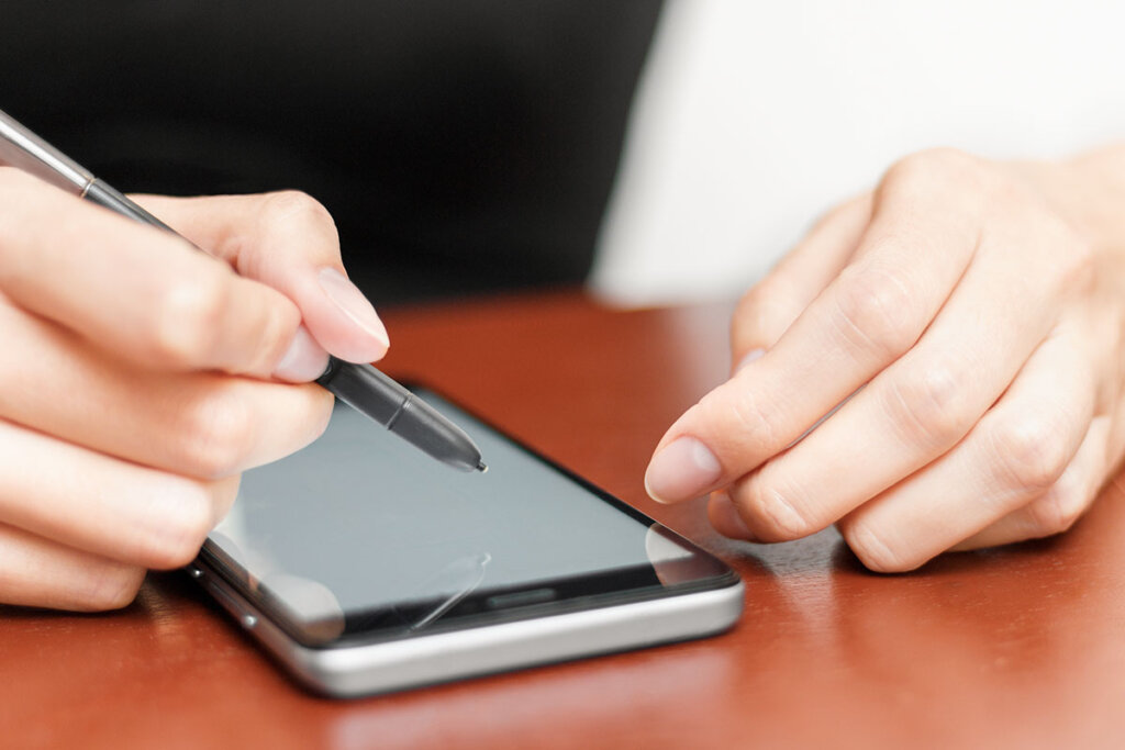 Vrouw bedient smartphone met stylus